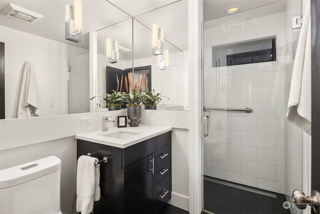 full bathroom with a stall shower, visible vents, vanity, and toilet