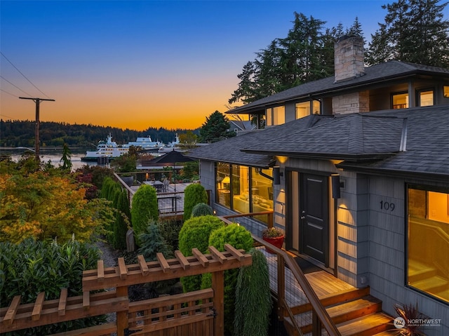 exterior space featuring roof with shingles