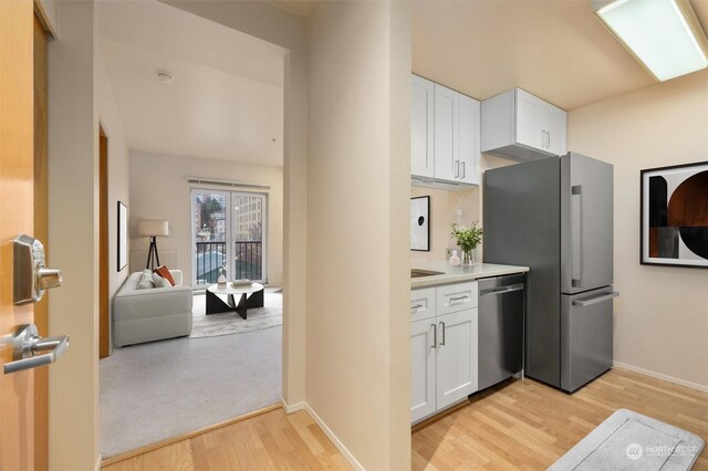 kitchen featuring white cabinets, light hardwood / wood-style floors, and stainless steel appliances