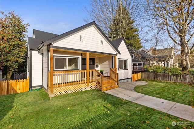 bungalow-style house with a deck and a front lawn