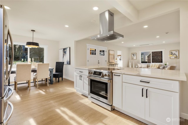 kitchen featuring white cabinets, hanging light fixtures, wall chimney exhaust hood, light stone countertops, and appliances with stainless steel finishes