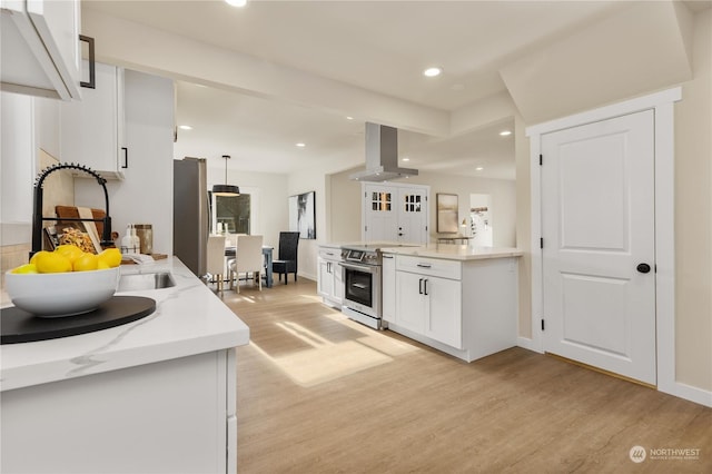 kitchen featuring appliances with stainless steel finishes, wall chimney exhaust hood, sink, light hardwood / wood-style flooring, and white cabinetry