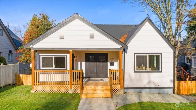 bungalow featuring covered porch and a front lawn