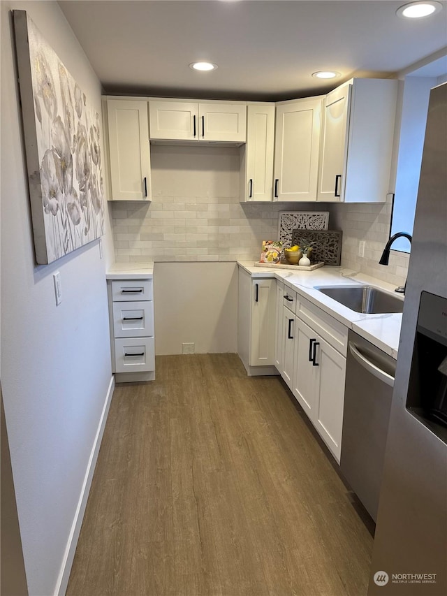 kitchen featuring decorative backsplash, dark hardwood / wood-style flooring, sink, dishwasher, and white cabinetry