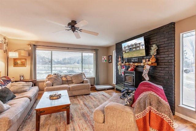 living room featuring a wood stove, plenty of natural light, and light wood-type flooring