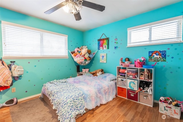 bedroom featuring multiple windows, ceiling fan, and hardwood / wood-style flooring