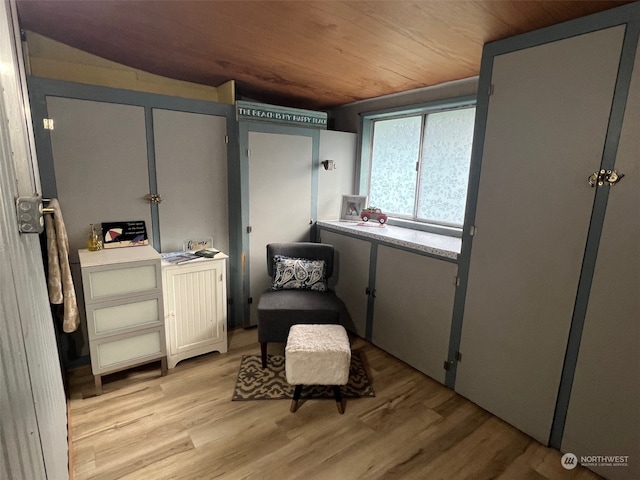 sitting room with lofted ceiling, light wood-type flooring, and wooden ceiling