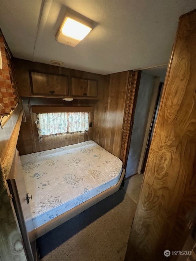 bedroom featuring wood walls