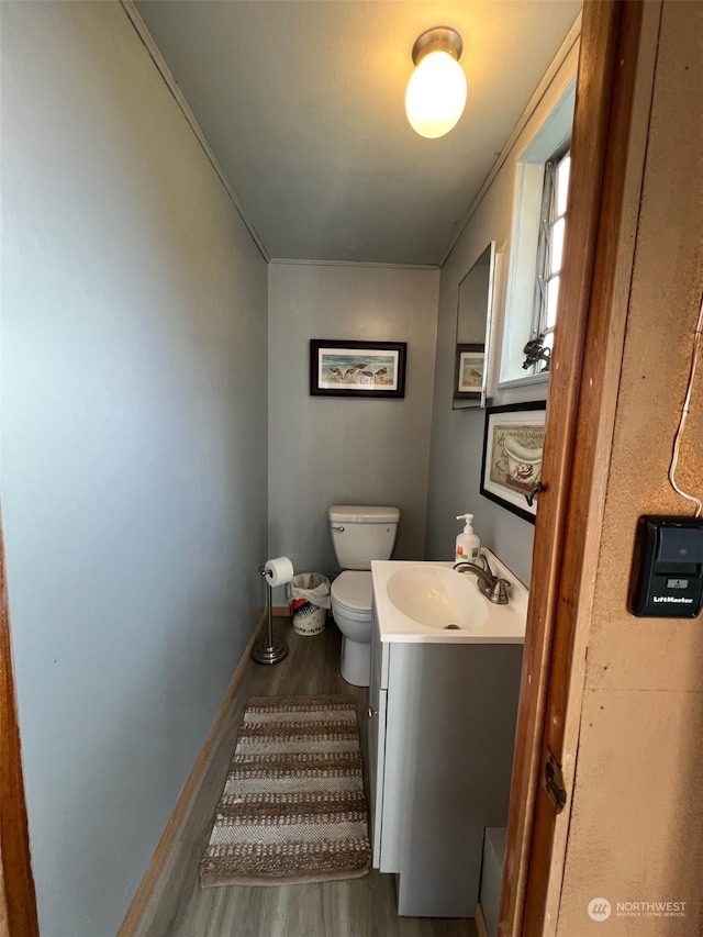 bathroom with hardwood / wood-style floors, vanity, and toilet