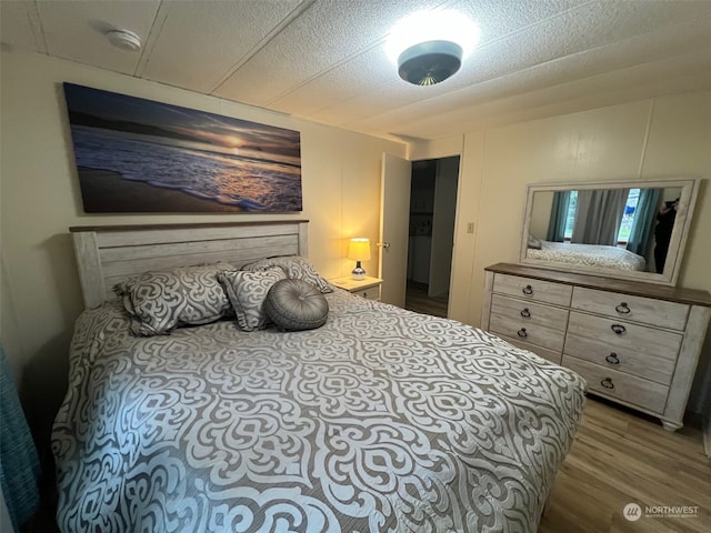 bedroom featuring wood-type flooring and a textured ceiling