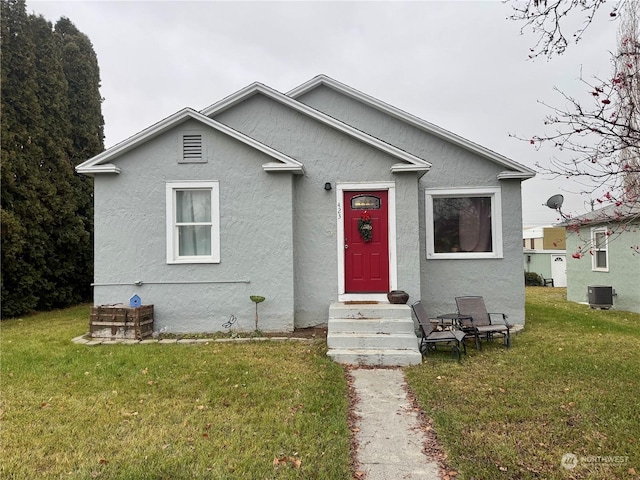 bungalow featuring a front yard and central air condition unit