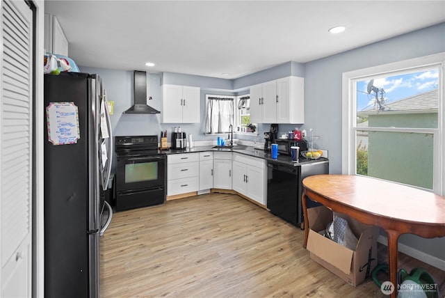 423 3rd Ave NE, Soap Lake, WA 98851 - kitchen with black appliances, wall chimney exhaust hood, a sink, white cabinets, and light wood-style floors