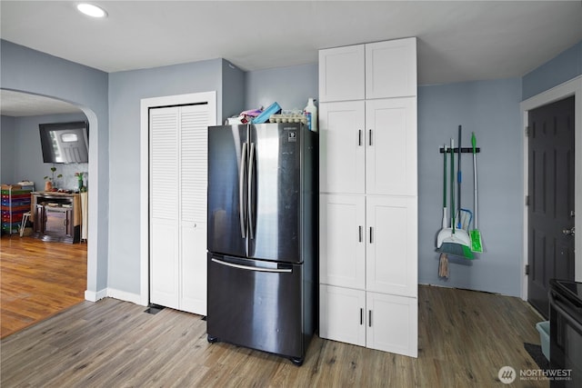 423 3rd Ave NE, Soap Lake, WA 98851 - kitchen featuring freestanding refrigerator, arched walkways, wood finished floors, white cabinetry, and recessed lighting