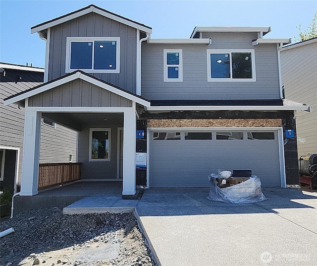 view of front facade with board and batten siding, driveway, and a garage