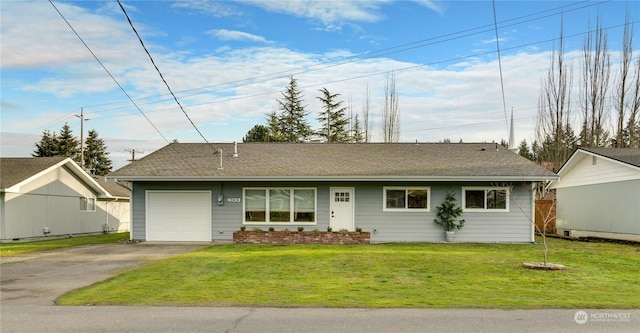 ranch-style home featuring a garage and a front lawn