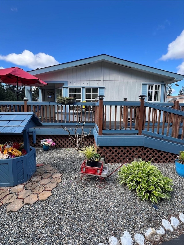 rear view of house featuring a wooden deck