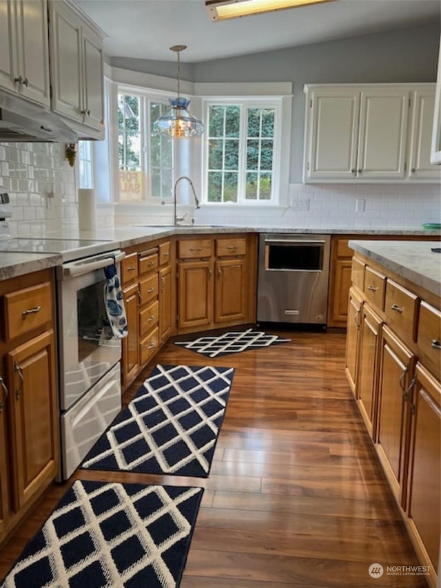 kitchen featuring pendant lighting, stainless steel appliances, a healthy amount of sunlight, and hardwood / wood-style floors