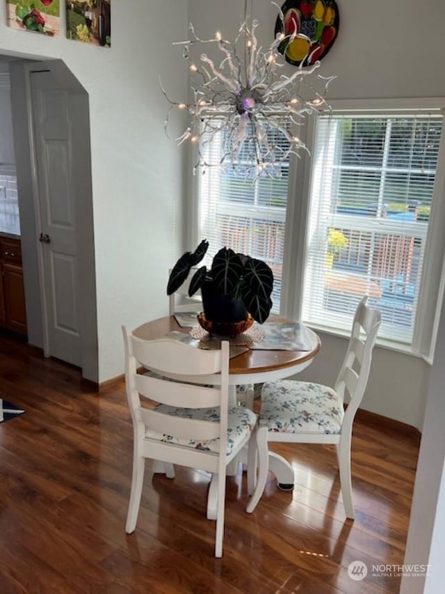 dining room featuring dark hardwood / wood-style flooring and an inviting chandelier