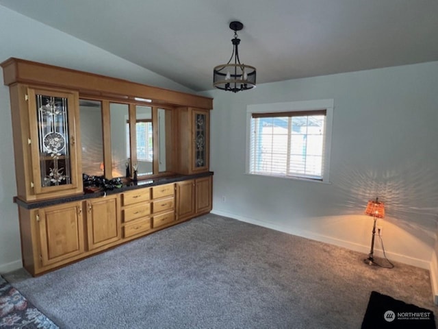 interior space featuring carpet, an inviting chandelier, and vaulted ceiling