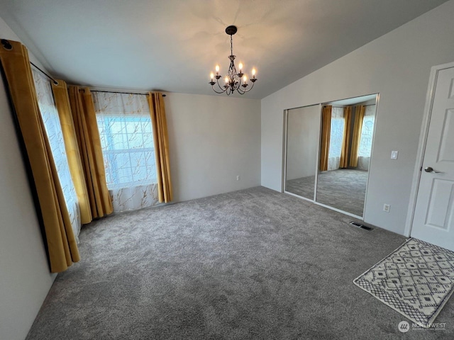 unfurnished bedroom with carpet flooring, a notable chandelier, vaulted ceiling, and multiple windows