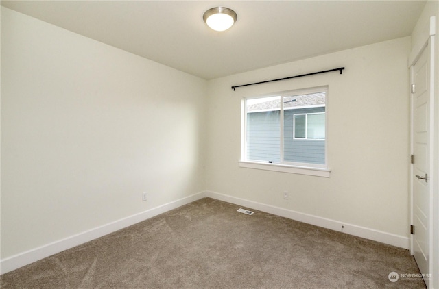 carpeted empty room with visible vents and baseboards