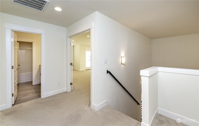 corridor with carpet floors, recessed lighting, visible vents, an upstairs landing, and baseboards