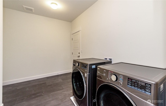 clothes washing area with laundry area, baseboards, visible vents, washer and clothes dryer, and dark wood-style flooring