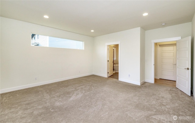 unfurnished bedroom featuring carpet floors, recessed lighting, baseboards, and ensuite bathroom