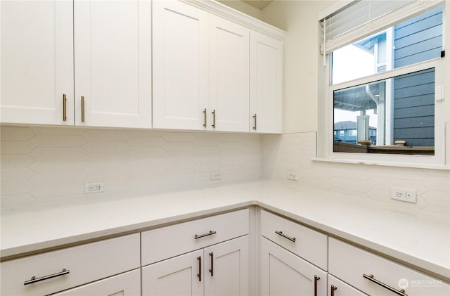 interior space featuring white cabinets and backsplash