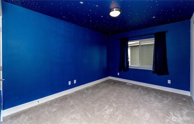 carpeted empty room featuring visible vents and baseboards