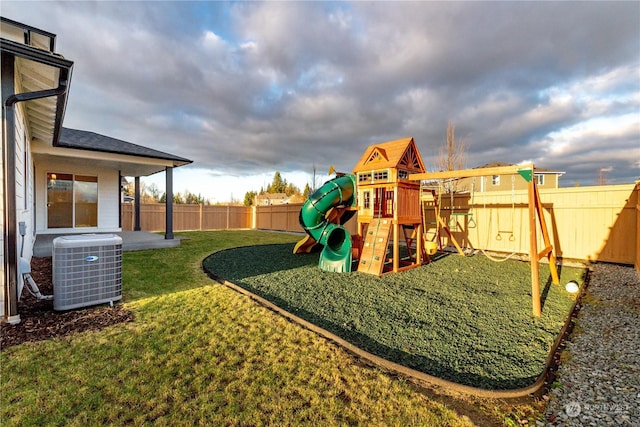 view of playground with central air condition unit, a patio area, a fenced backyard, and a lawn