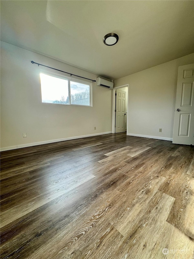 empty room with dark wood-type flooring and a wall unit AC