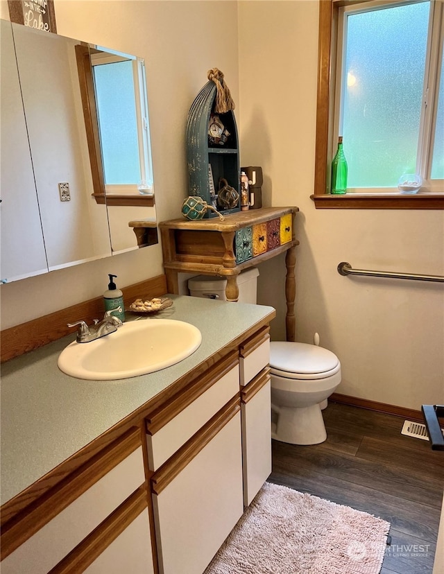 bathroom featuring hardwood / wood-style flooring, toilet, and vanity