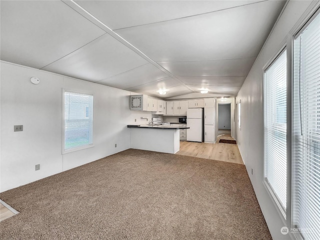 unfurnished living room with light hardwood / wood-style flooring, lofted ceiling, and sink