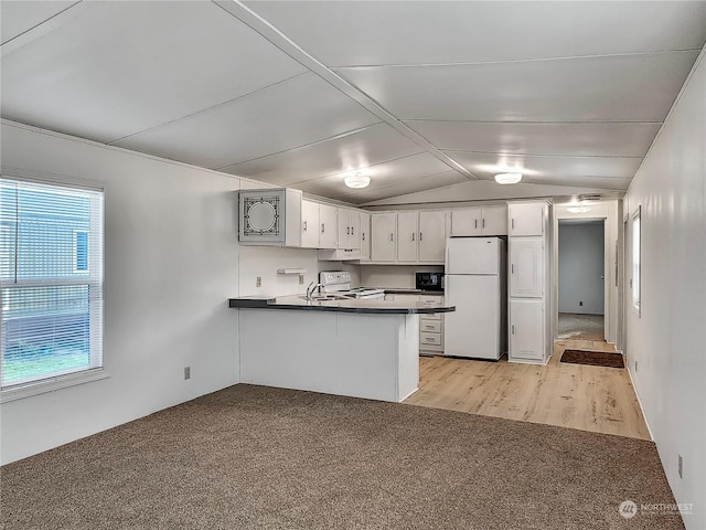 kitchen with kitchen peninsula, white appliances, vaulted ceiling, light hardwood / wood-style flooring, and white cabinetry