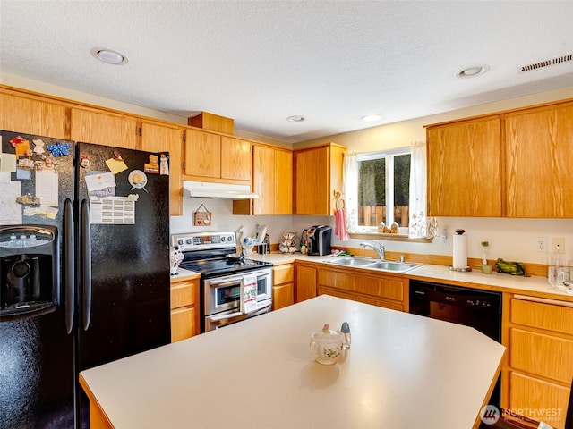 kitchen featuring light countertops, brown cabinetry, a sink, under cabinet range hood, and black appliances