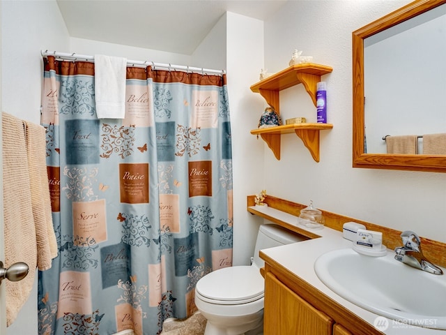 bathroom featuring toilet, a shower with shower curtain, and vanity