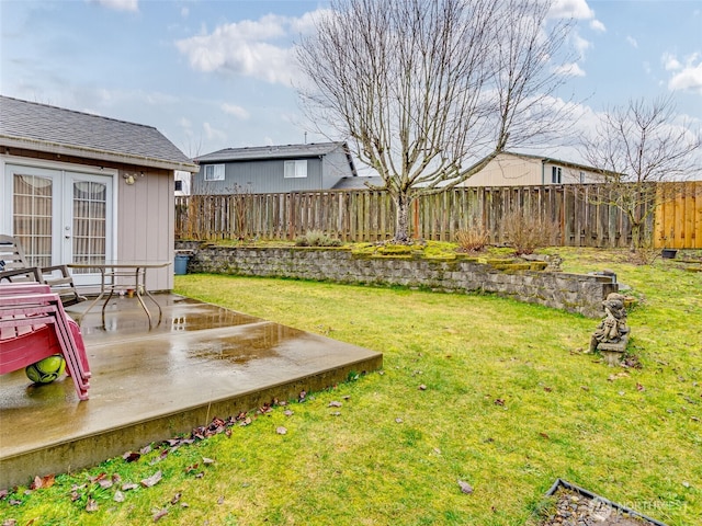 view of yard featuring a patio, french doors, and a fenced backyard