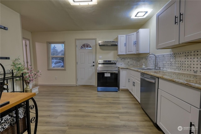 kitchen with white cabinets, appliances with stainless steel finishes, light wood-type flooring, and range hood