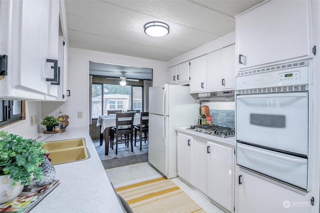 kitchen featuring ceiling fan, sink, stainless steel gas cooktop, decorative backsplash, and white cabinets