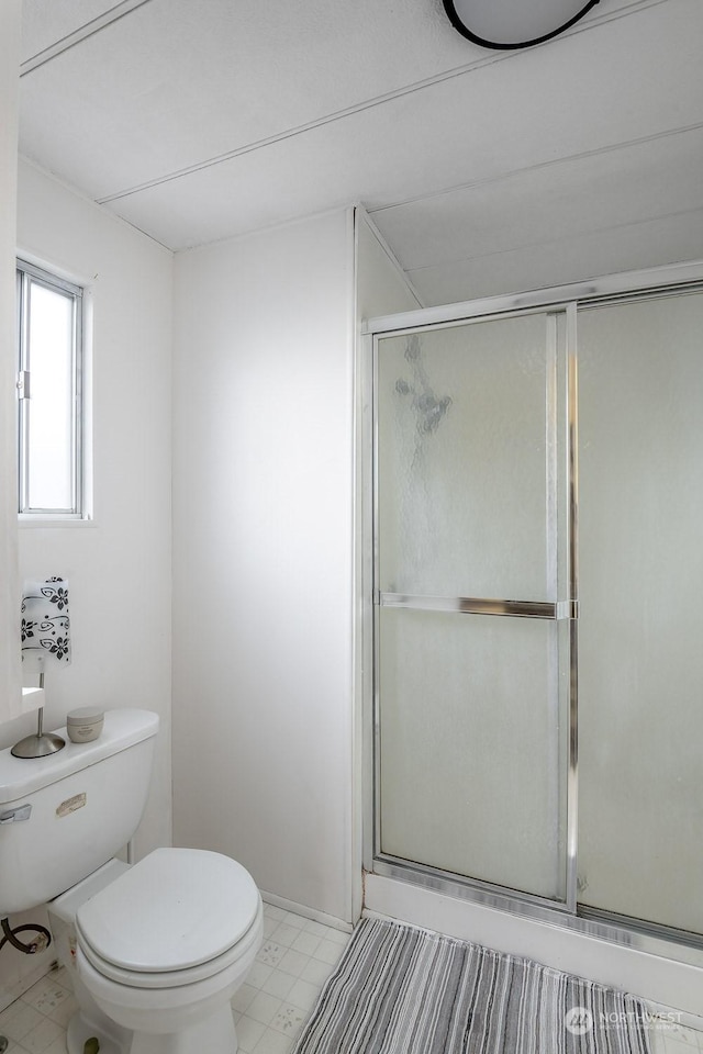 bathroom with toilet and an enclosed shower