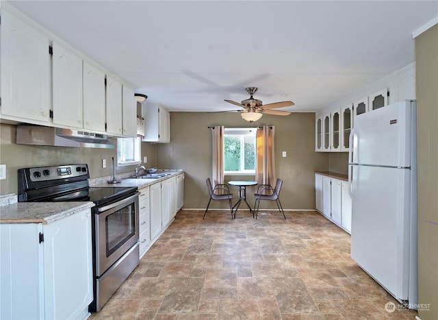 kitchen with light stone countertops, stainless steel electric stove, ceiling fan, white refrigerator, and white cabinetry