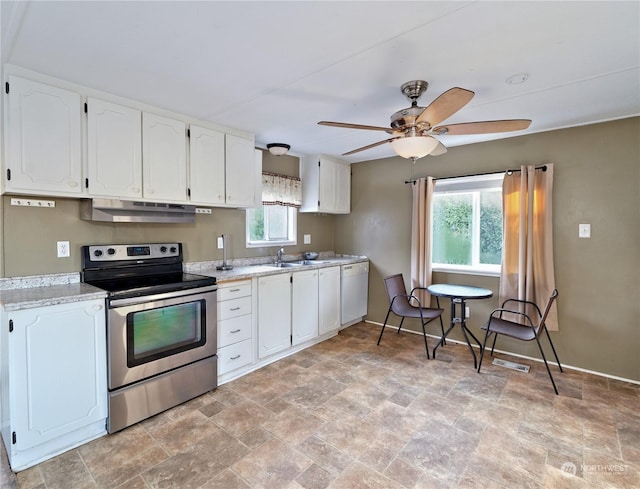 kitchen with white cabinets, white dishwasher, a wealth of natural light, and stainless steel electric range