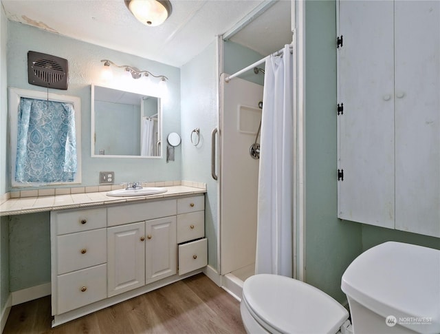 bathroom with hardwood / wood-style flooring, vanity, curtained shower, and toilet