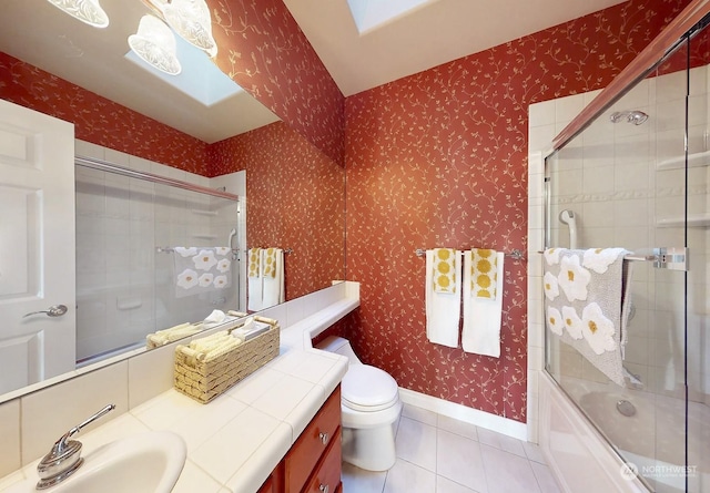 full bathroom with tile patterned floors, toilet, combined bath / shower with glass door, and vanity