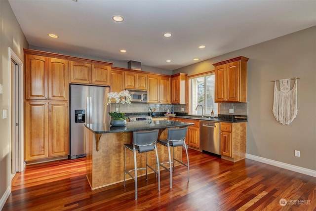 kitchen featuring dark stone countertops, dark hardwood / wood-style flooring, a kitchen island, and appliances with stainless steel finishes