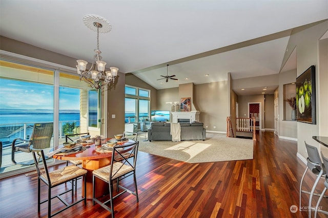 dining space with dark hardwood / wood-style flooring, ceiling fan with notable chandelier, and lofted ceiling