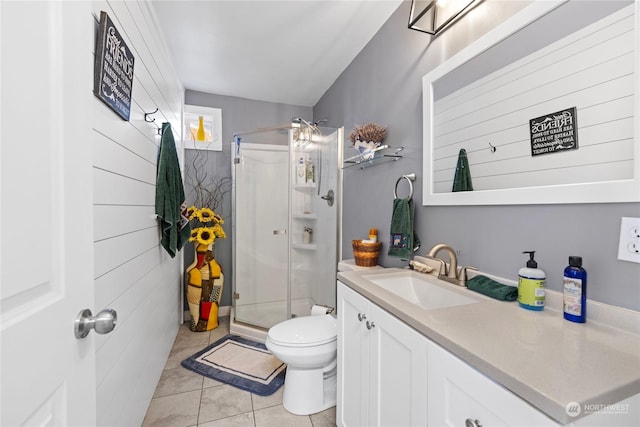 bathroom featuring toilet, vanity, tile patterned floors, and a shower with door