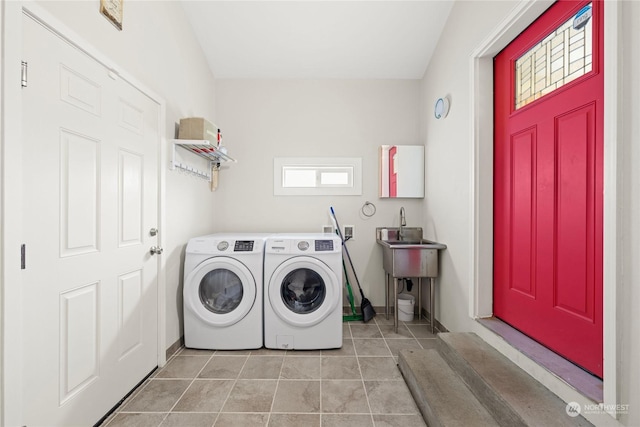 clothes washing area with sink, light tile patterned flooring, and washer and dryer