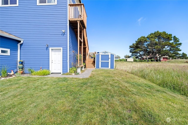 view of yard featuring a wooden deck and a storage shed